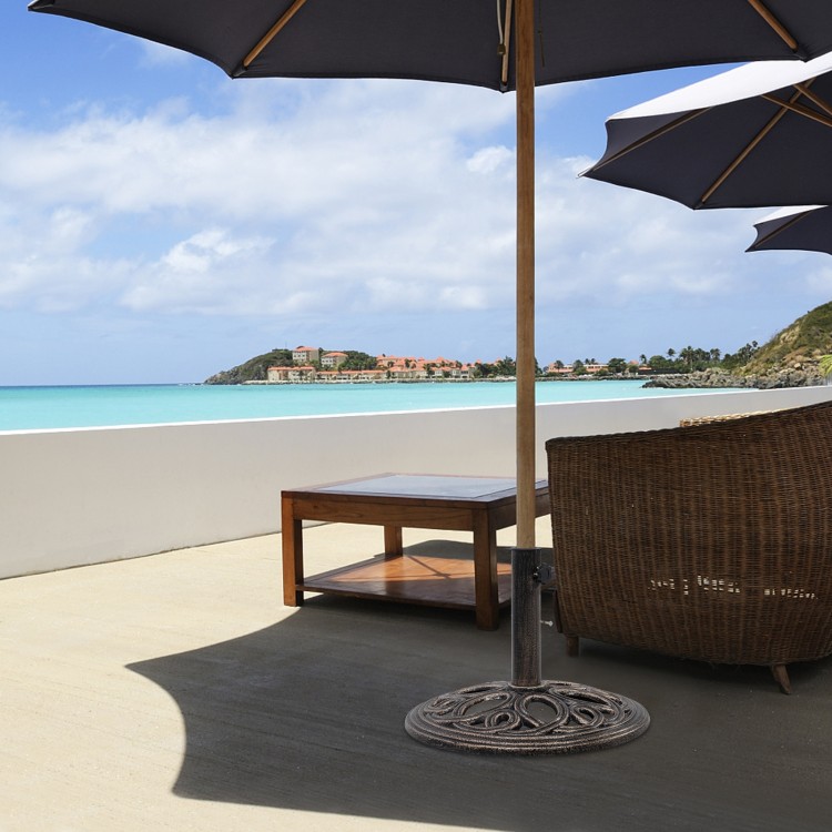 Round umbrella base stand made of premium cast iron in classic bronze, providing stability for patio umbrellas outdoors.