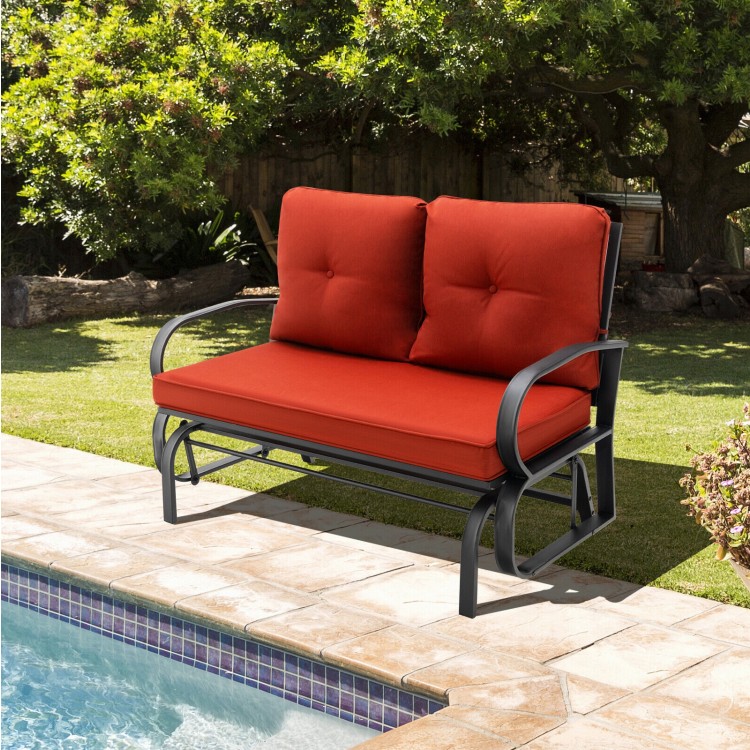 Brick red cushioned patio glider loveseat with sturdy steel frame, perfect for outdoor relaxation by the pool.