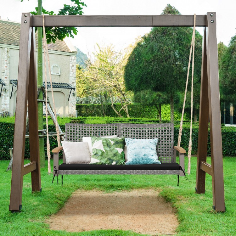 Spacious 2-person patio wicker hanging swing chair in black with acacia wood armrests, ideal for backyard relaxation.