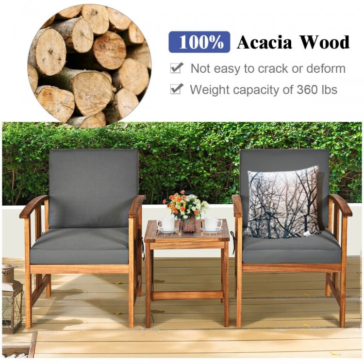 Two gray cushioned chairs and a coffee table made of 100% acacia wood, perfect for outdoor patio use.