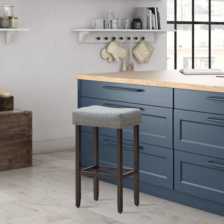 Gray nailhead saddle bar stool with solid rubberwood legs, 29-inch height, ideal for kitchens and bars.