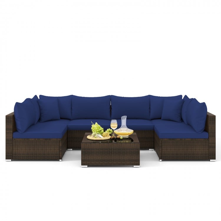 Sectional sofa set with navy cushions, made of PE rattan, includes coffee table, ideal for patio and garden relaxation.