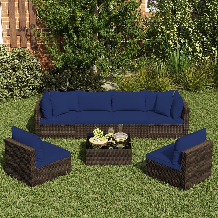 Sectional patio rattan furniture set with navy cushions, includes coffee table and four seating pieces for outdoor.