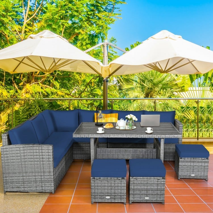 7-piece patio rattan dining furniture set with navy cushions, featuring a sectional sofa, table, and ottomans for.