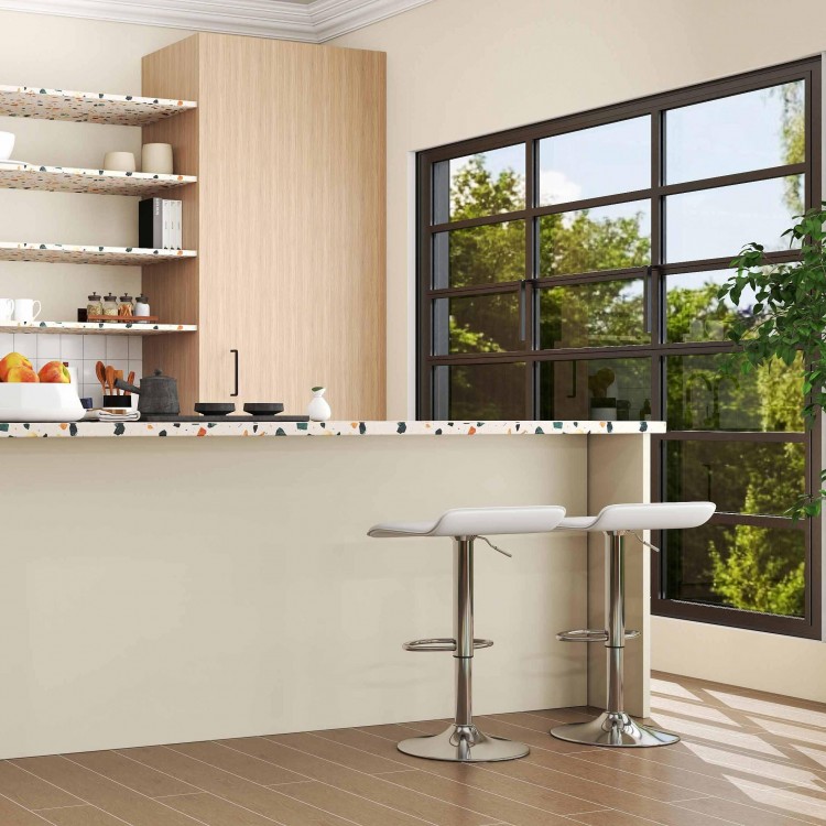 Mid-century dining set featuring adjustable white PU leather bar stools and a glass dining table in a modern kitchen.
