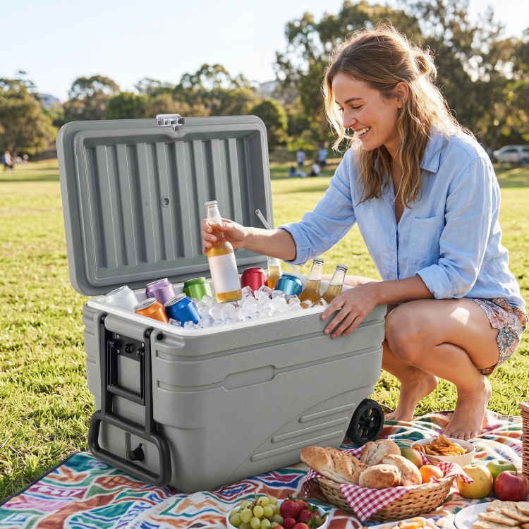 Portable 84 Quart gray ice cooler with wheels, filled with drinks and ice, perfect for outdoor picnics and gatherings.