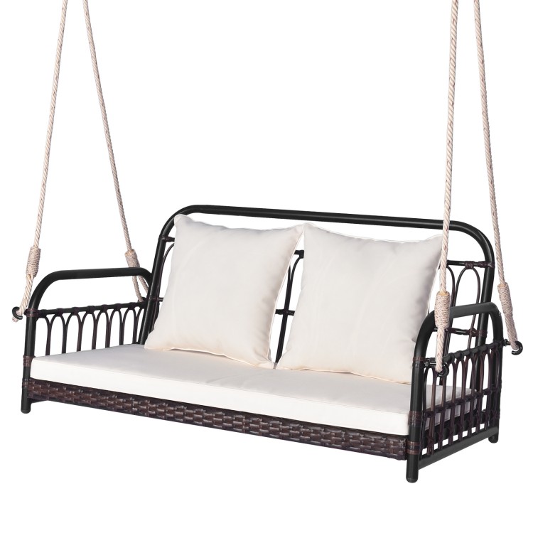 Wicker hanging porch swing with white cushions, 880 lbs capacity, ideal for outdoor relaxation in gardens or backyards.