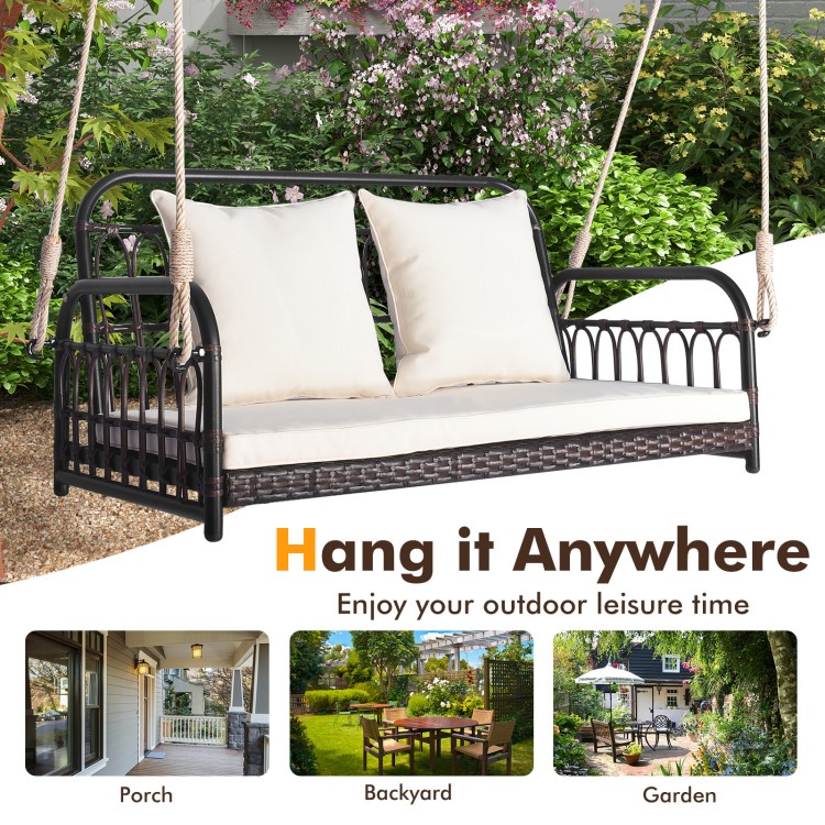 Wicker hanging porch swing with white cushions, 880 lbs capacity, ideal for outdoor relaxation in garden or backyard.