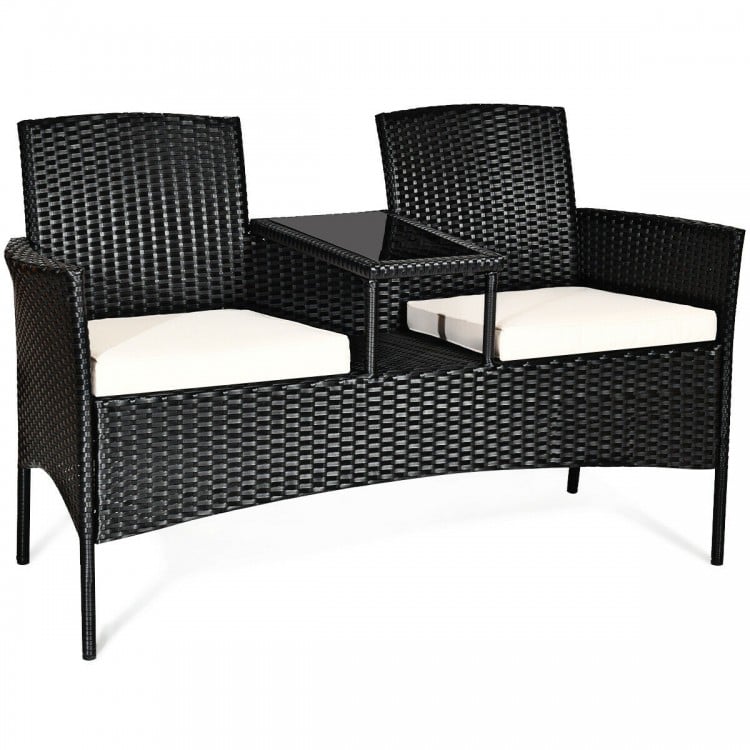 Wicker patio conversation set with removable cushions and tempered glass table, ideal for garden or balcony use.