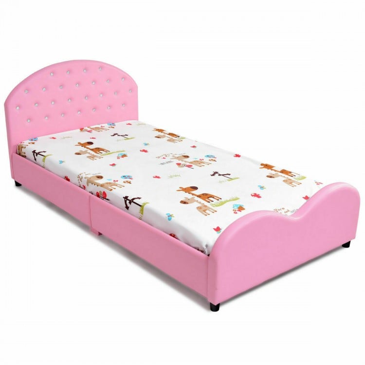 Twin size upholstered toddler bed in pink with soft foam padding and non-toxic varnish for safe sleeping conditions.