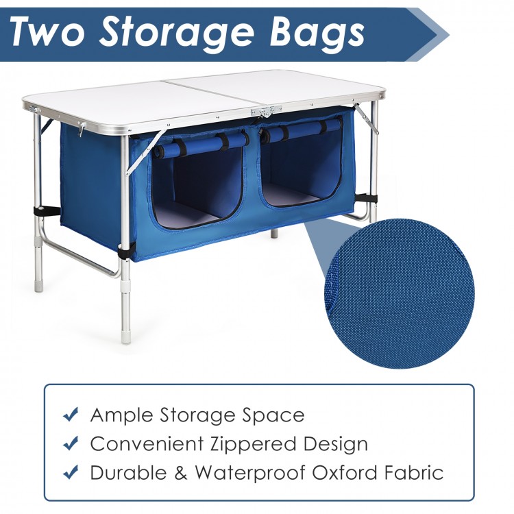 Height adjustable folding camping table in blue with two storage bags, made of durable waterproof Oxford fabric.