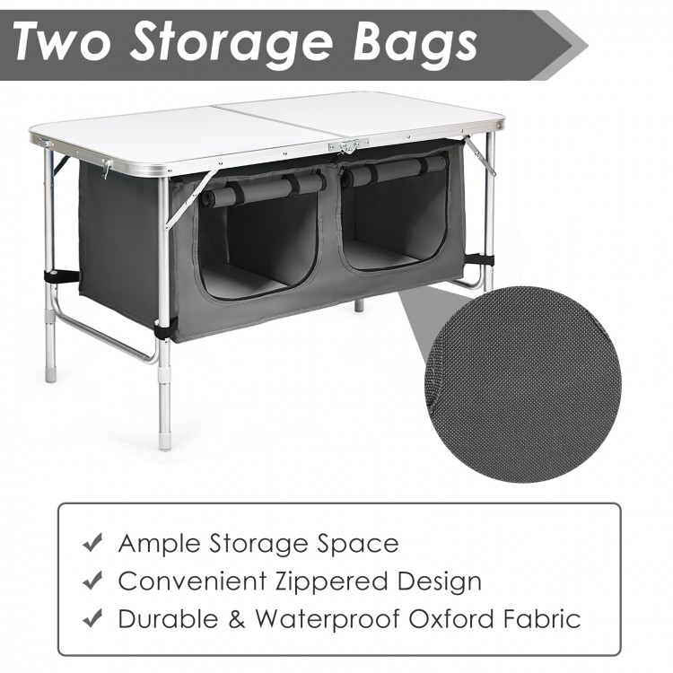 Height adjustable gray folding camping table with two storage bags, made of durable waterproof Oxford fabric.