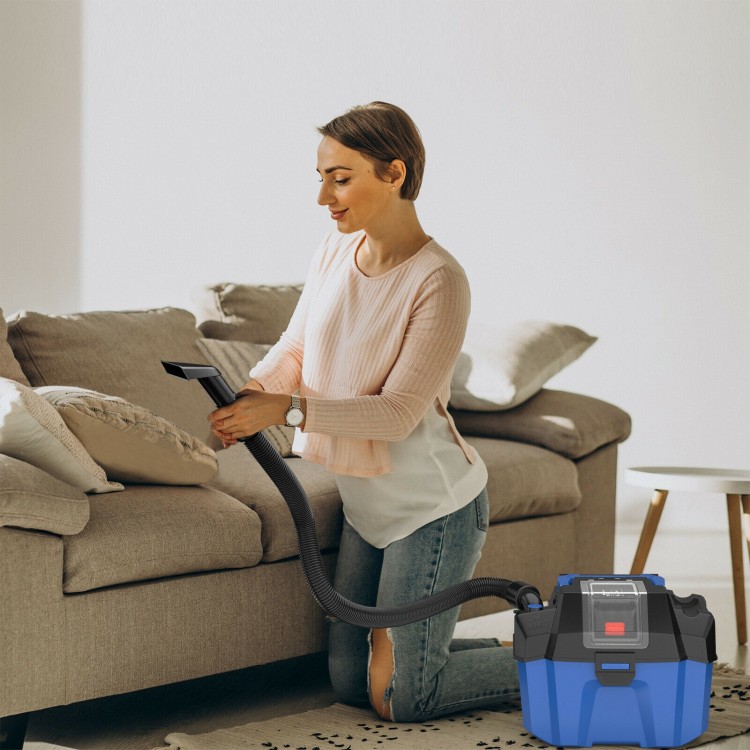 Cordless 18V wet-dry vacuum in blue, shown in use for cleaning a couch, featuring a 2.7-gallon tank and ergonomic.
