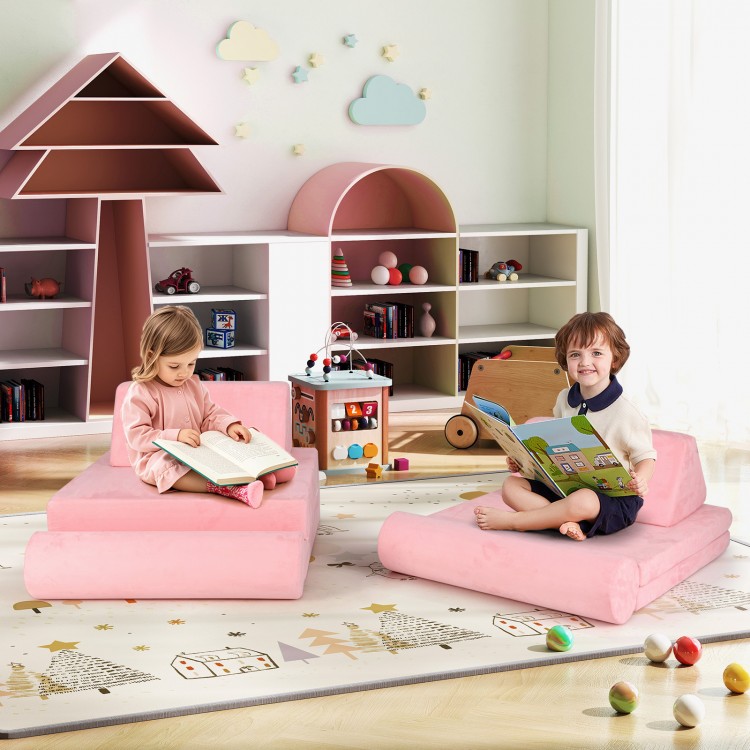 Kids sitting on pink modular foam play couch set, reading books in a bright playroom with soft suede covers.