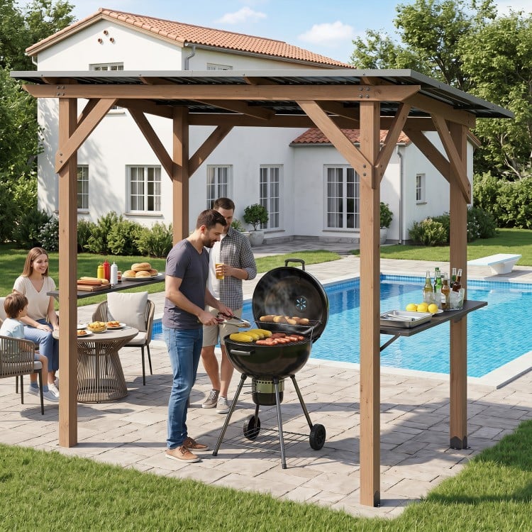 Cedar wood BBQ gazebo with a sloped metal roof and two side serving shelves, ideal for outdoor grilling and gatherings.