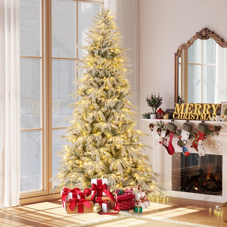 Snow-flocked 8-foot artificial Christmas tree with warm white LED lights, surrounded by colorful wrapped gifts.