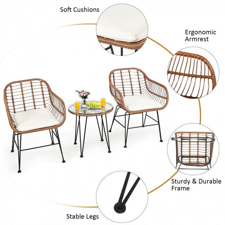 Two armchairs and a side table from the 3 Pieces Patio Rattan Bistro Set with white cushions, perfect for outdoor.