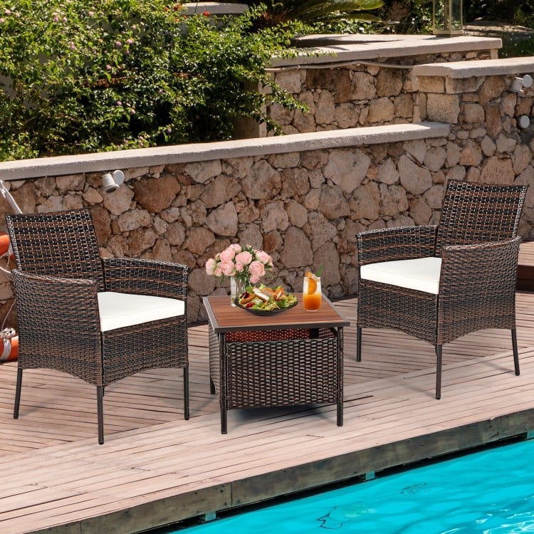 Two outdoor PE rattan armchairs with removable cushions, perfect for poolside relaxation and durable for all weather.
