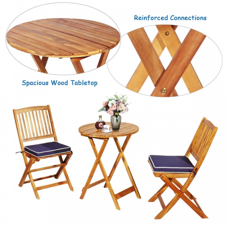 Folding wooden bistro set with cushioned chairs in navy, featuring a spacious acacia wood tabletop for outdoor use.