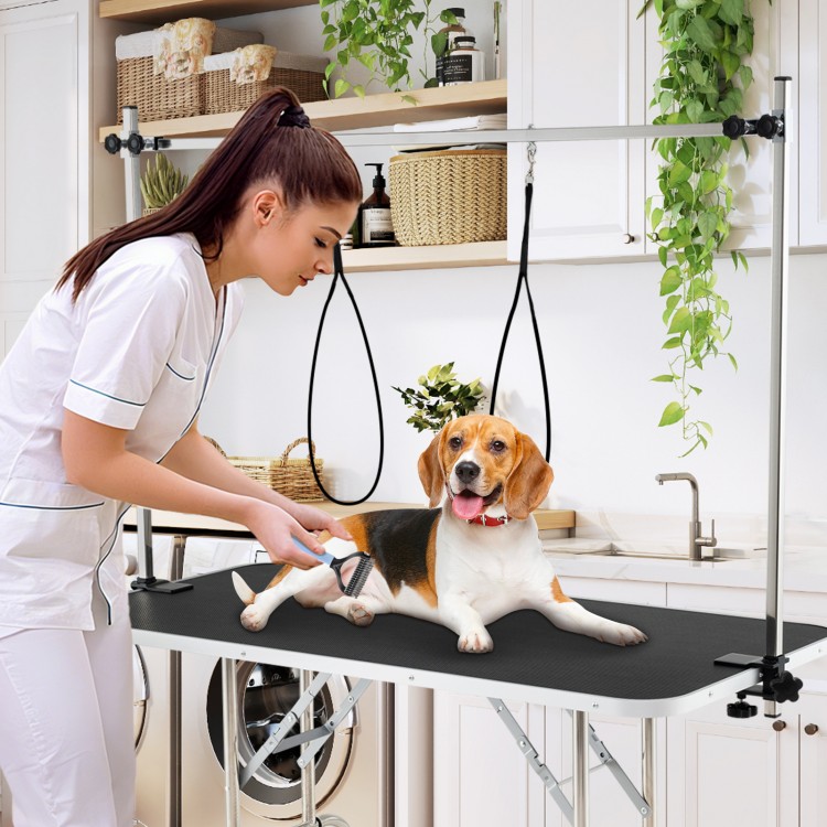 Foldable dog grooming table with height adjustable arms, non-slip surface, and storage tray for pet care and grooming.