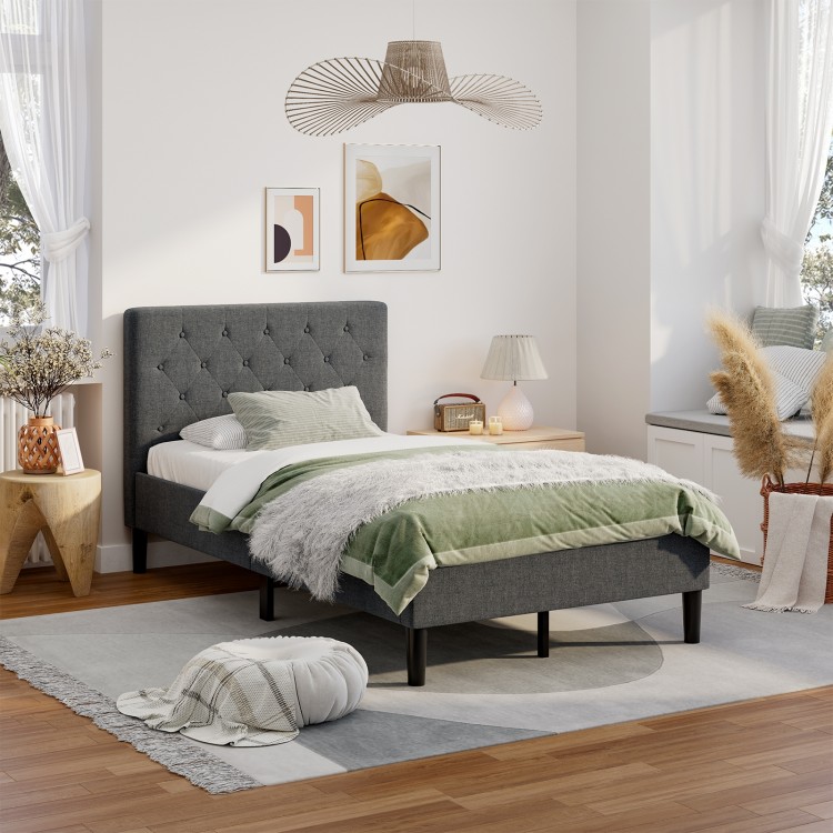 Upholstered bed base with button stitched headboard in a modern bedroom, featuring soft fabric and under-bed storage.