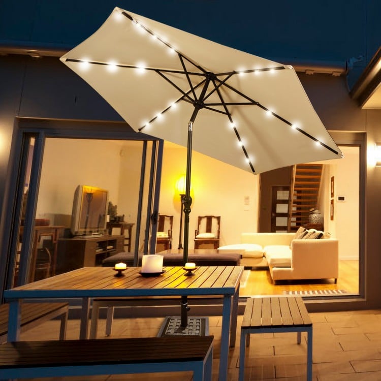Heavy-duty 30 lbs square umbrella base stand with bronze finish, securely holding an umbrella for outdoor use.