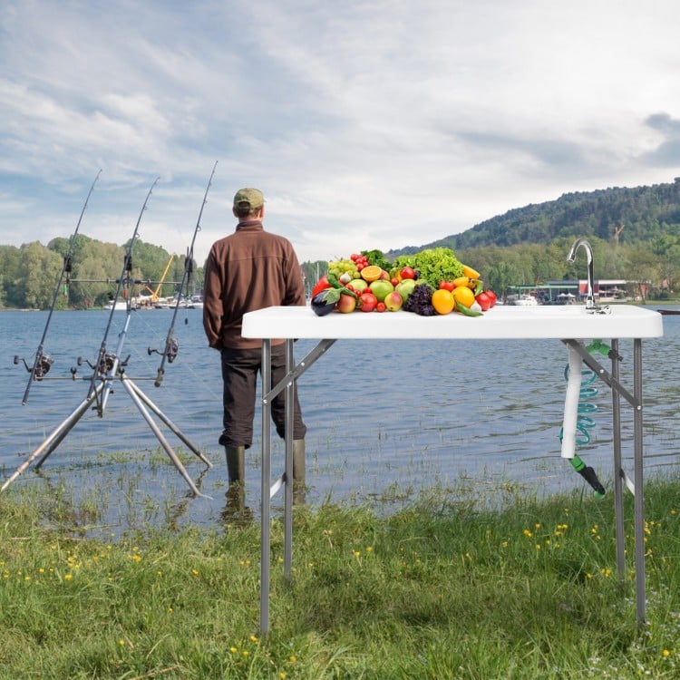 Folding cleaning sink table with sprayer, perfect for outdoor use, featuring a durable surface and integrated drain.