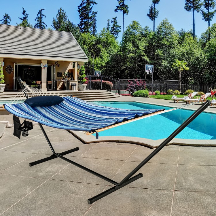 Hammock chair stand set with blue striped cotton fabric and pillow, placed by a pool for outdoor relaxation.