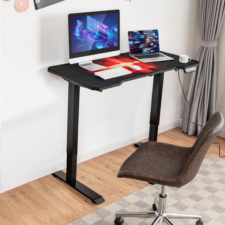 Electric standing gaming desk with height-adjustable splice board, carbon fiber texture, ideal for gaming and work.