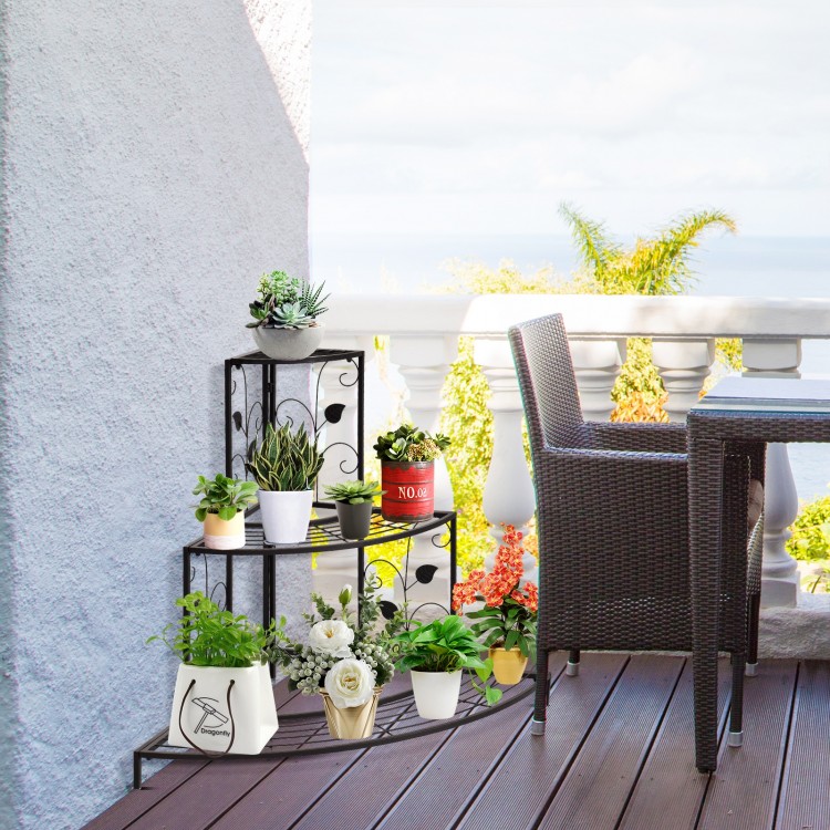 Three-tier floral corner metal plant pot rack in black, ideal for displaying potted plants on a patio or balcony.