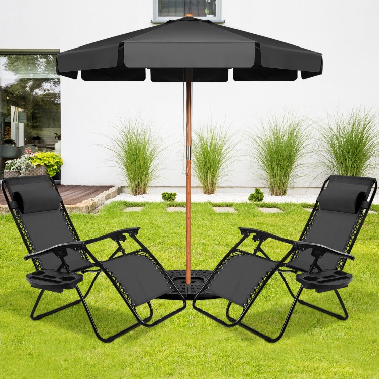 Two black folding lounge chairs with zero gravity design under a patio umbrella, perfect for outdoor relaxation.