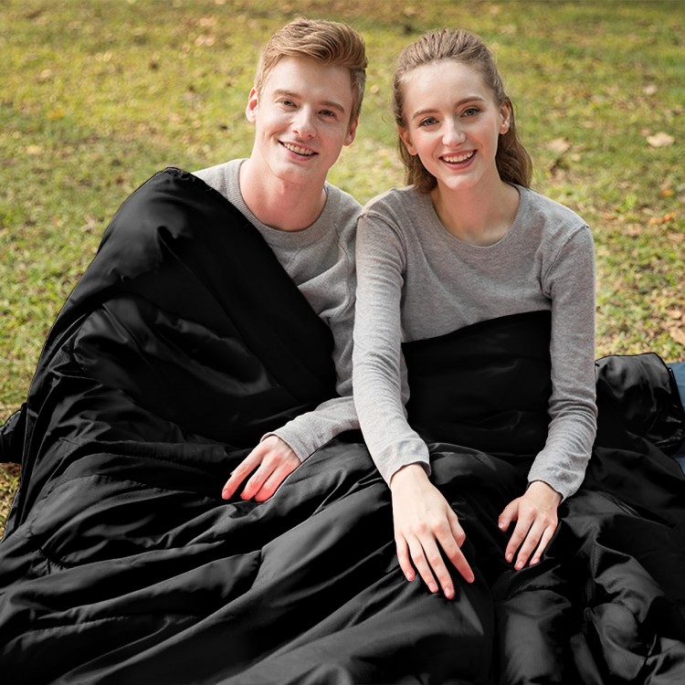 Couple enjoying the 2 Person Waterproof Sleeping Bag in black, perfect for camping and outdoor adventures.