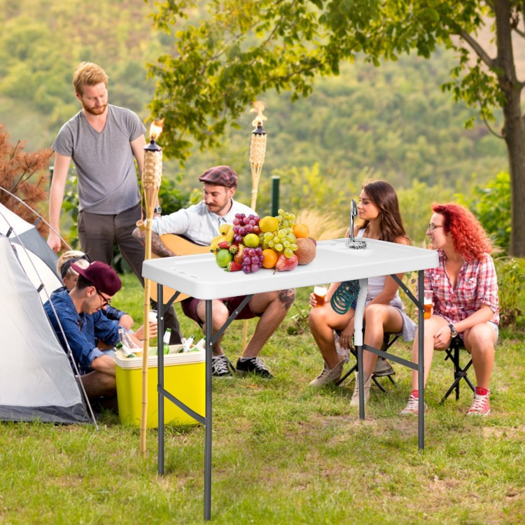 Folding cleaning sink table with sprayer, sturdy plastic surface, perfect for outdoor cooking and cleaning tasks.