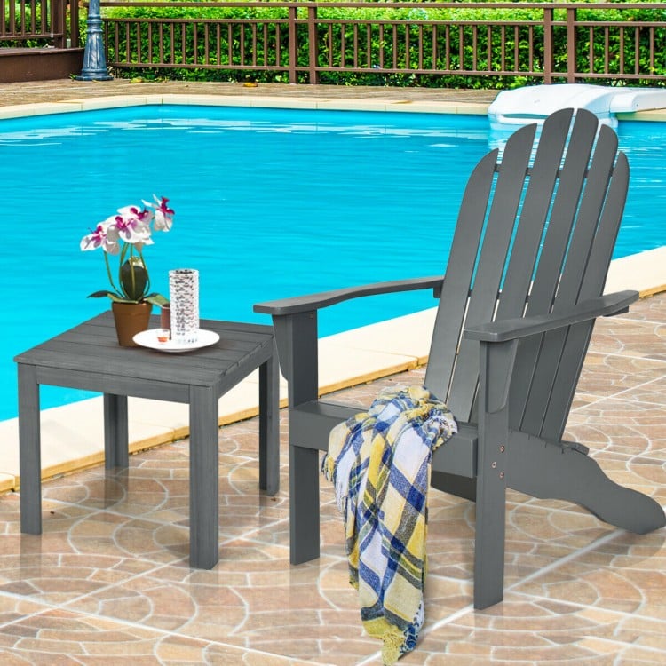 Gray acacia wood Adirondack chair with ergonomic design, perfect for outdoor relaxation by the poolside.