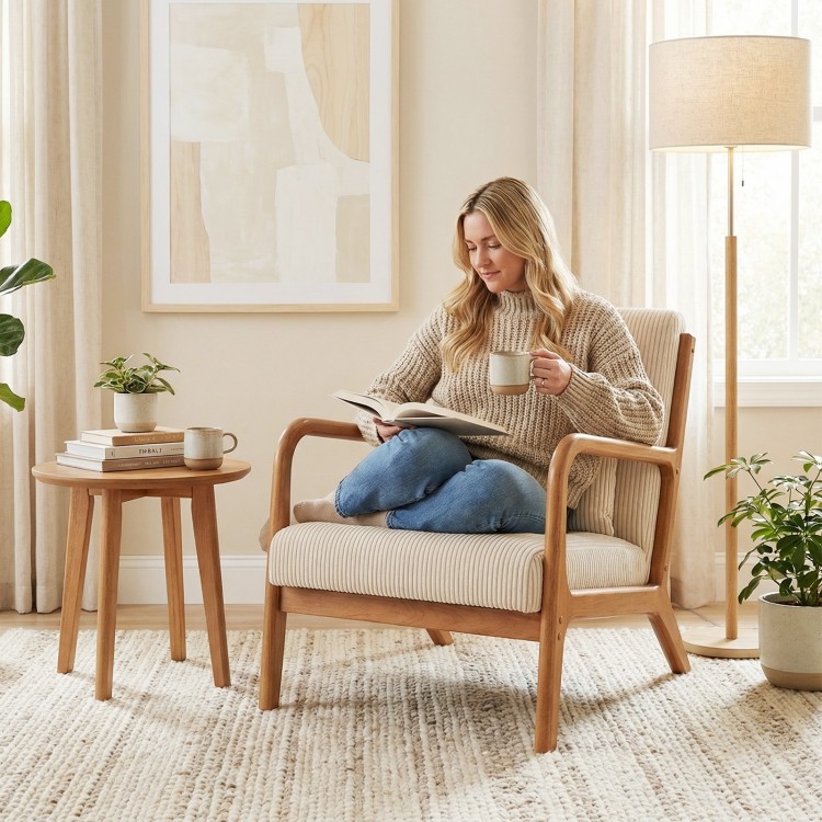 Beige corduroy accent chair with lumbar pillow, featuring a solid wood frame, perfect for cozy reading in any room.