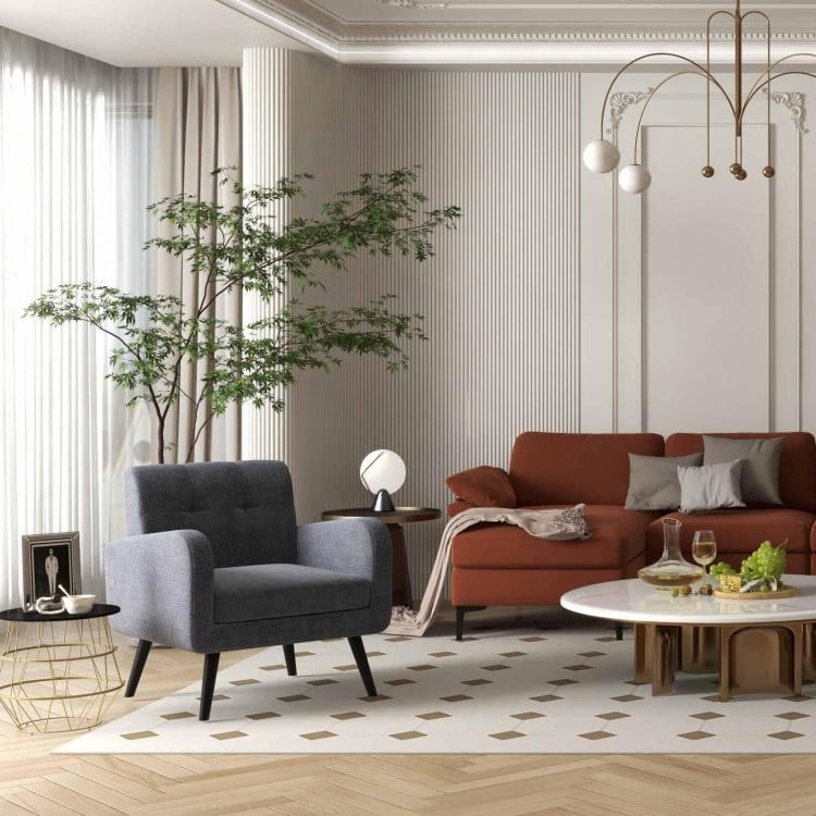 Modern accent chair with soft cushion, L-shaped sectional sofa, and round side table in a stylish living room setting.
