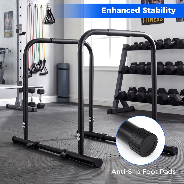 Adjustable dip bar station in black with anti-slip foot pads, designed for stability and various workout exercises.