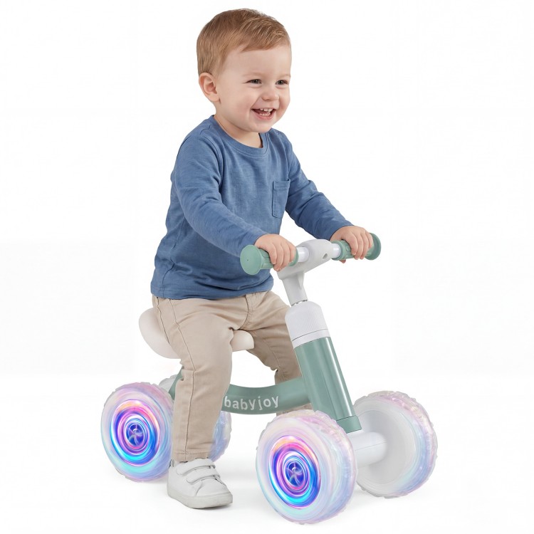 Baby balance bike in green with adjustable seat and glowing wheels, designed for indoor and outdoor fun for kids.