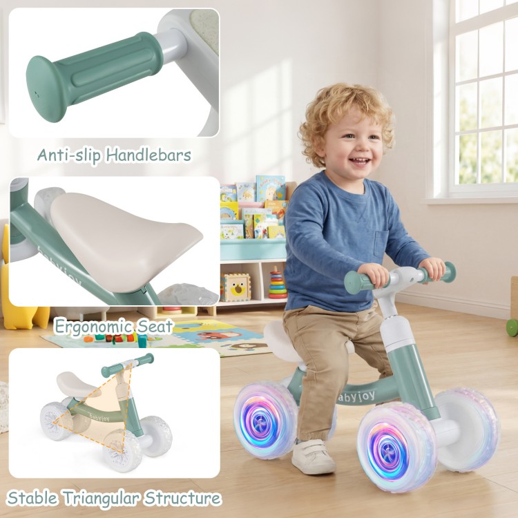 Baby balance bike in green with adjustable handlebars and ergonomic seat, featuring glowing wheels for indoor and.