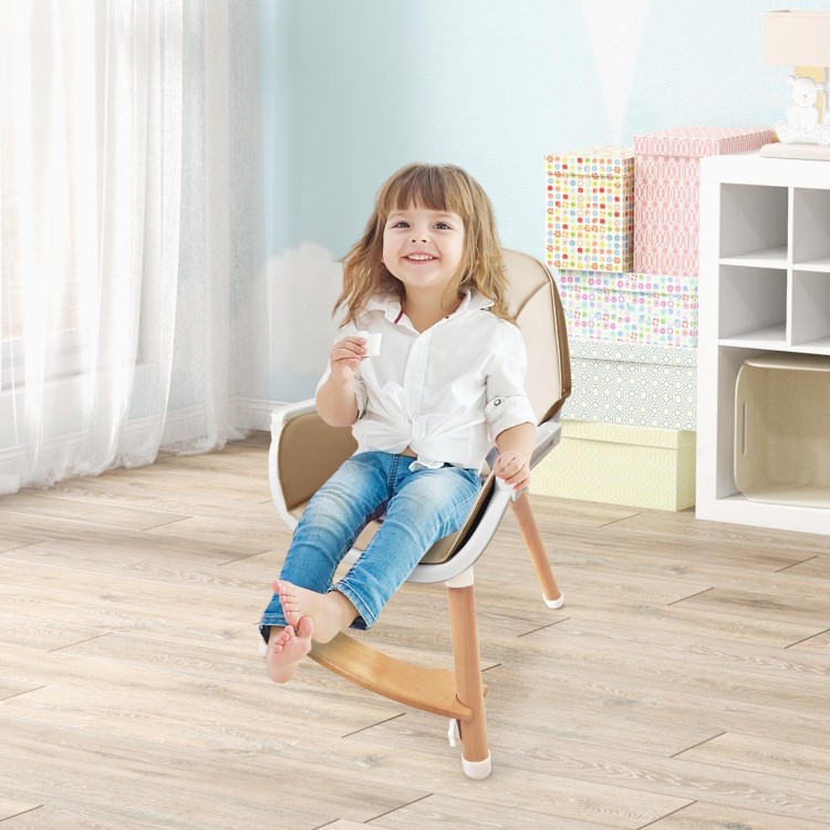 Child sitting in a beige baby high chair with solid beech wood legs and a dishwasher-safe tray for easy cleaning.