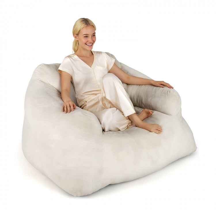 Plush beige bean bag chair with overstuffed backrest and armrests, perfect for relaxing and lounging comfortably.