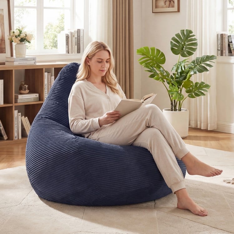 Blue bean bag chair with corduroy cover and soft sponge filling, perfect for reading and relaxing in any room.