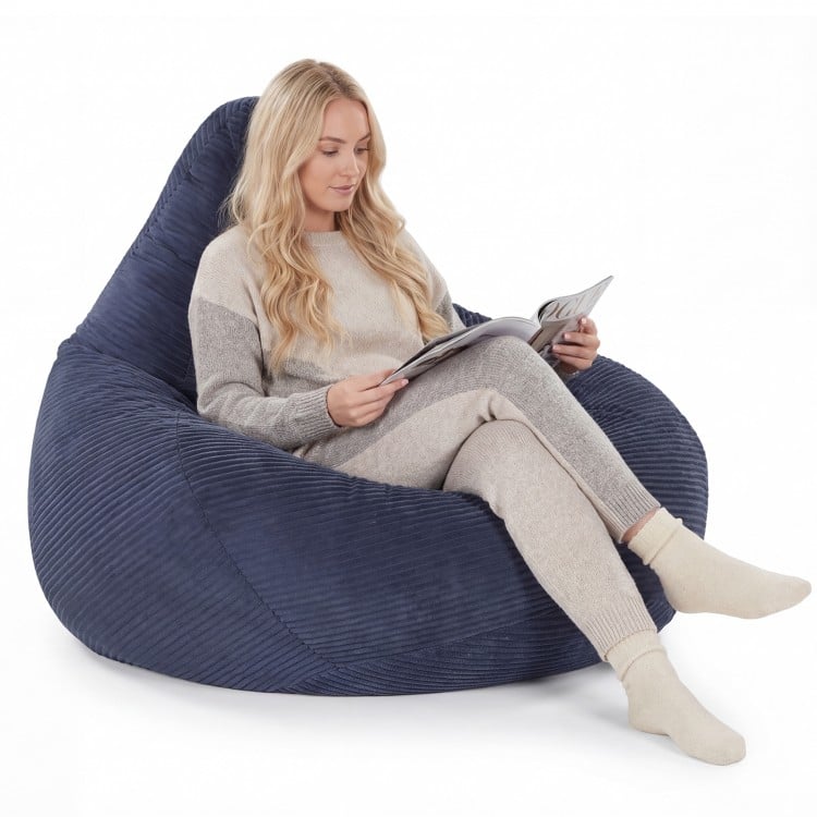 Bean bag chair in blue with a corduroy cover, featuring a woman reading comfortably in a cozy living space.