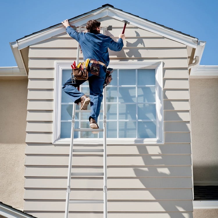 Folding aluminum step ladder with anti-skid pedal, used for home maintenance and repairs on a house exterior.