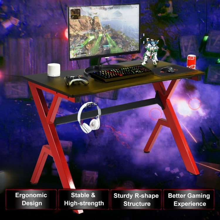 Ergonomic gaming desk with carbon fiber surface and R-shape steel frame, featuring a spacious tabletop and organized.