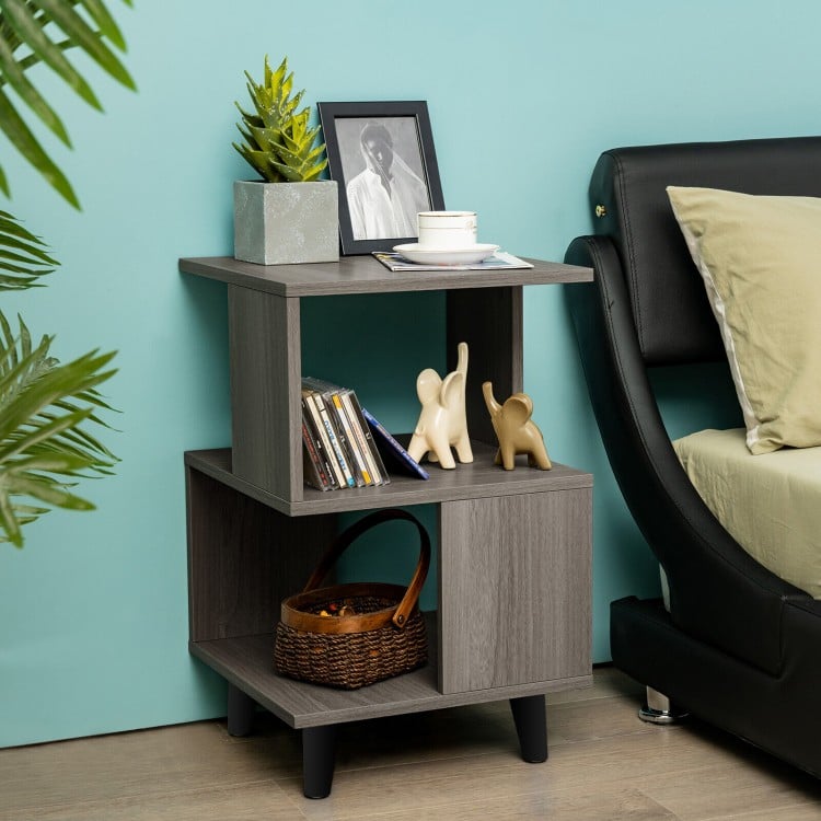 Modern wooden nightstand with asymmetrical design, featuring storage space and stable legs, ideal for small living.