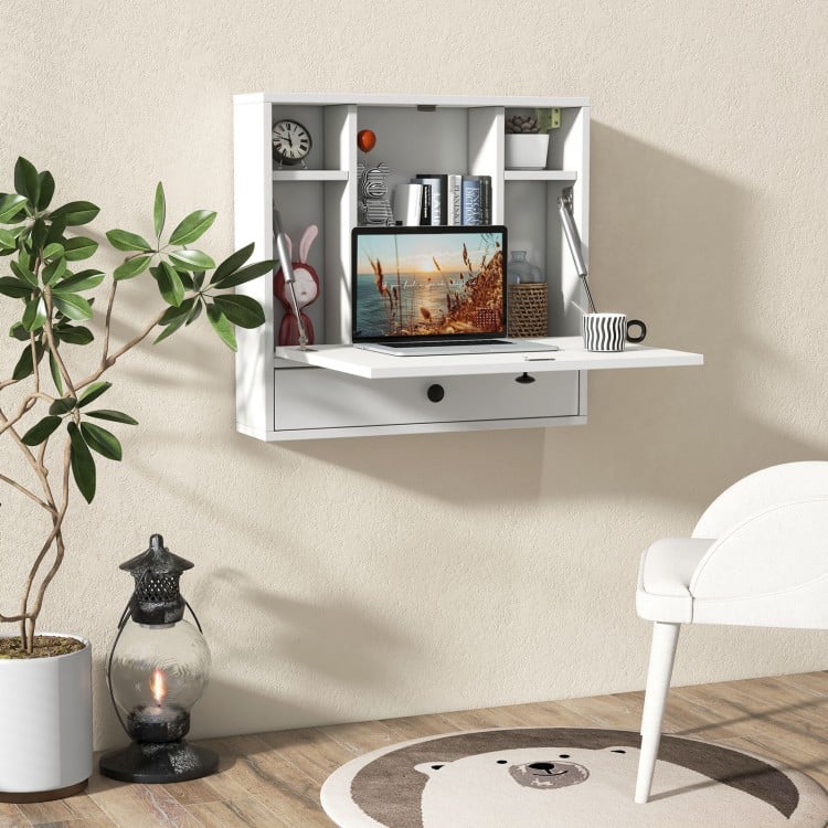 Wall-mount floating desk in white with foldable surface, open shelves, and drawer, ideal for small spaces.