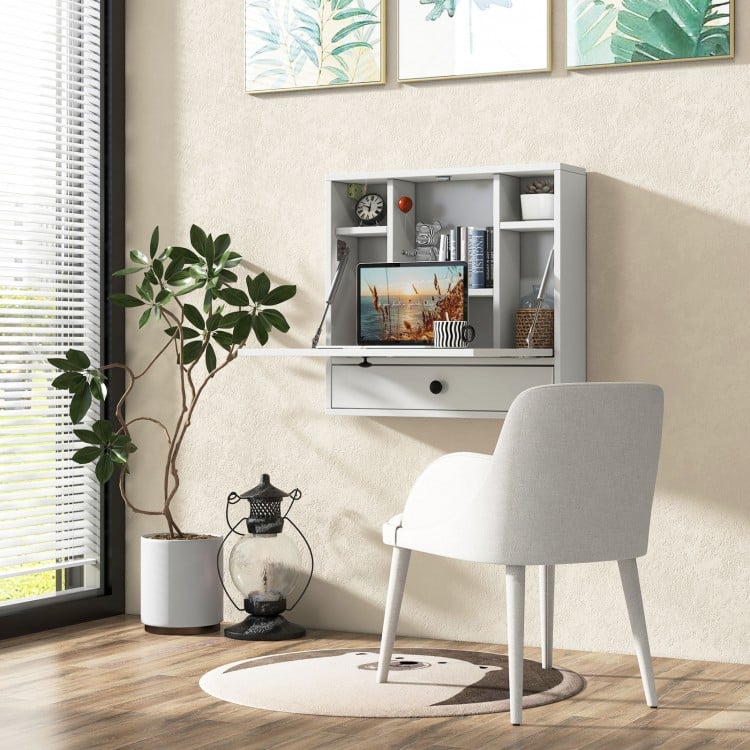 Wall-mount floating desk in white with foldable surface, open shelves, and drawer, perfect for small spaces.