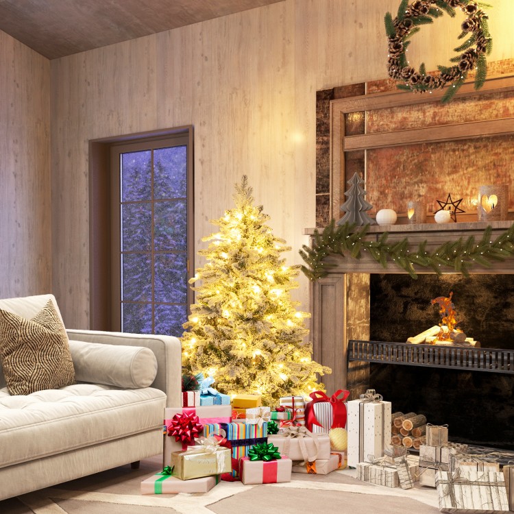 Flocked 4.5 ft Christmas tree with warm white LED lights, surrounded by colorful gifts in a cozy living room setting.