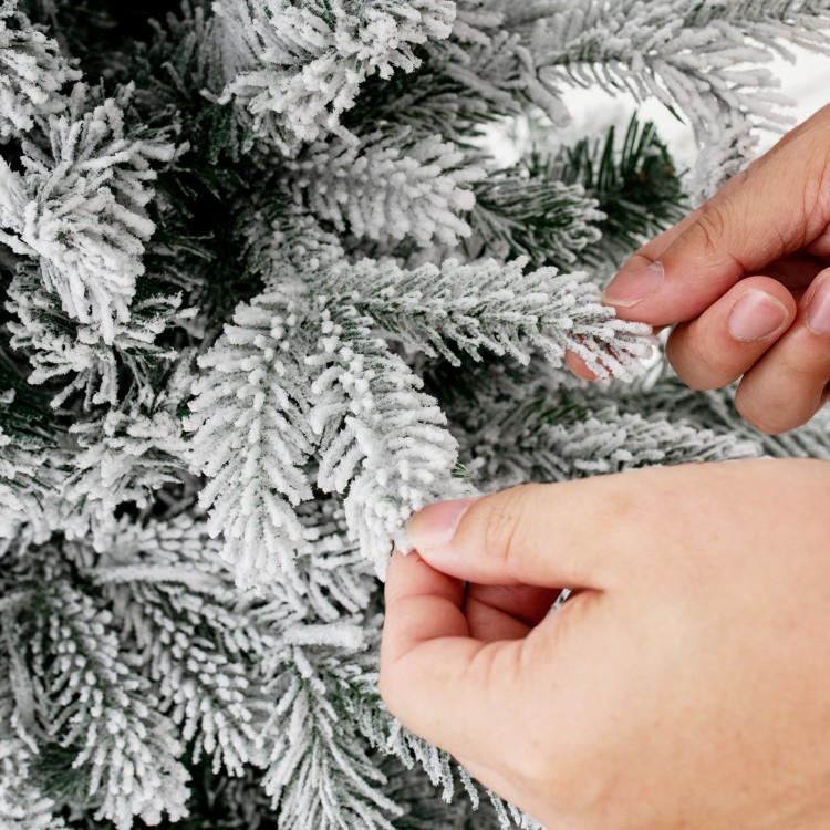 Close-up of snowy flocked branches on a 4.5 ft pre-lit Christmas tree with warm white LED lights for festive decor.